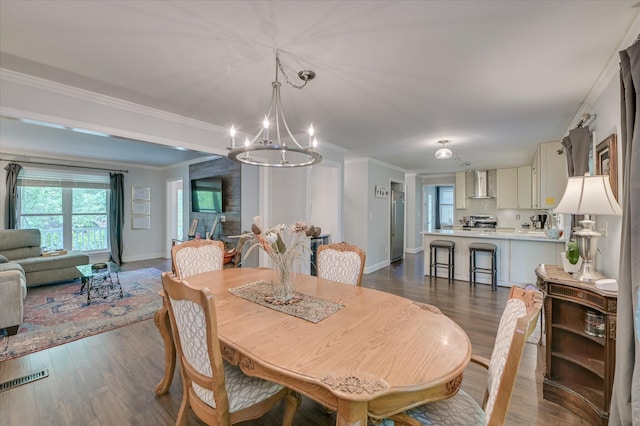 dining area with a chandelier, crown molding, dark wood-style flooring, and baseboards