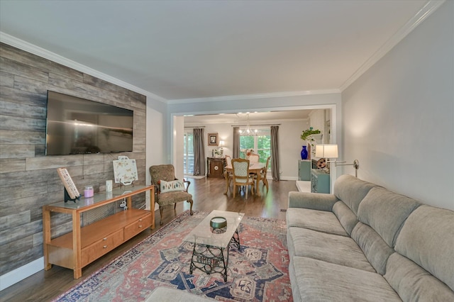 living room with wood finished floors, ornamental molding, and baseboards