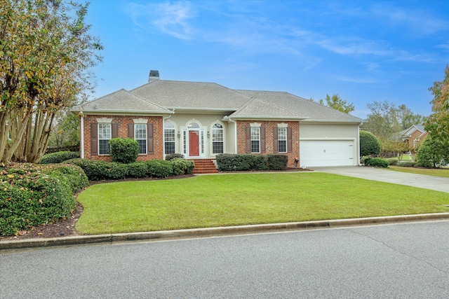 view of front of house with a garage and a front lawn