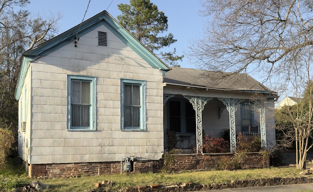 exterior space featuring covered porch and roof with shingles