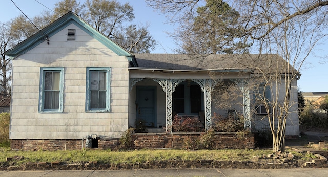 view of front facade featuring covered porch and roof with shingles