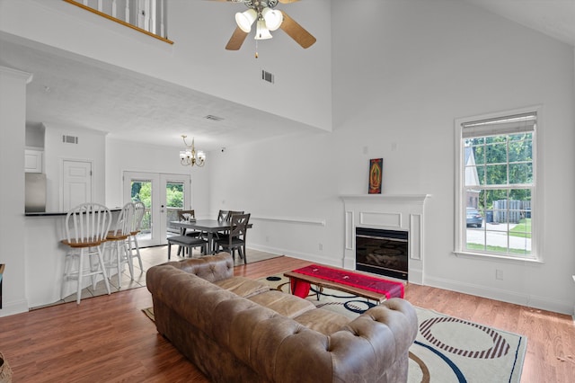 2532 Grier Cir, Evans, GA 30809 - living room featuring ceiling fan, wood finished floors, high vaulted ceiling, a glass covered fireplace, and a chandelier