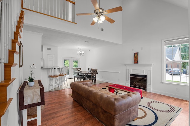 2532 Grier Cir, Evans, GA 30809 - living area featuring wood finished floors, a ceiling fan, a towering ceiling, a glass covered fireplace, and a chandelier