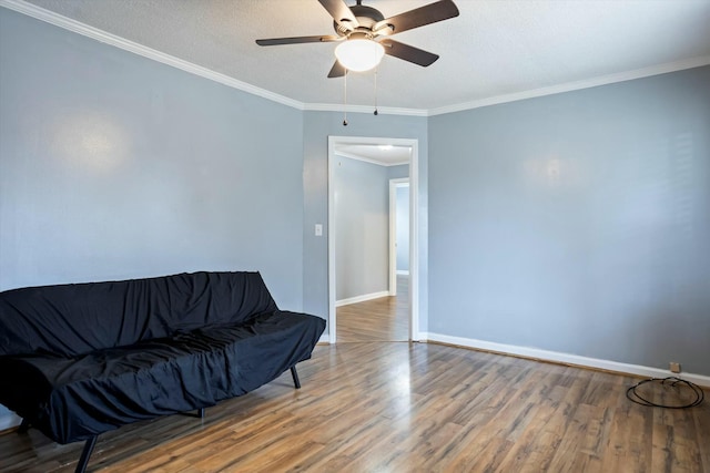 living area with hardwood / wood-style flooring, ornamental molding, ceiling fan, and a textured ceiling