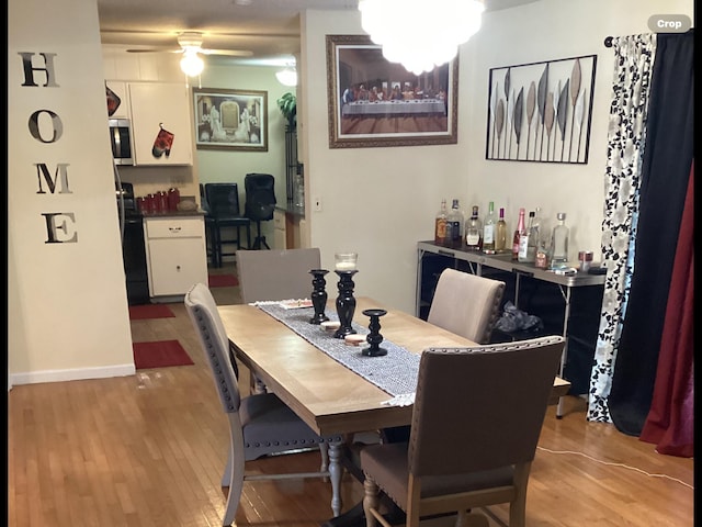 dining space featuring light wood-type flooring and ceiling fan