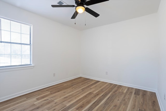 unfurnished room featuring ceiling fan, baseboards, and wood finished floors