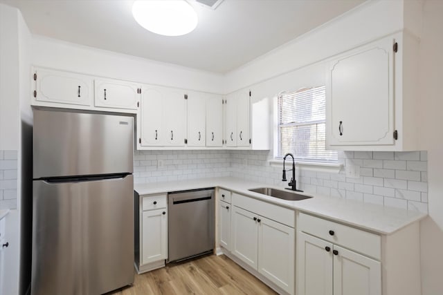 kitchen featuring a sink, stainless steel appliances, light countertops, and white cabinetry