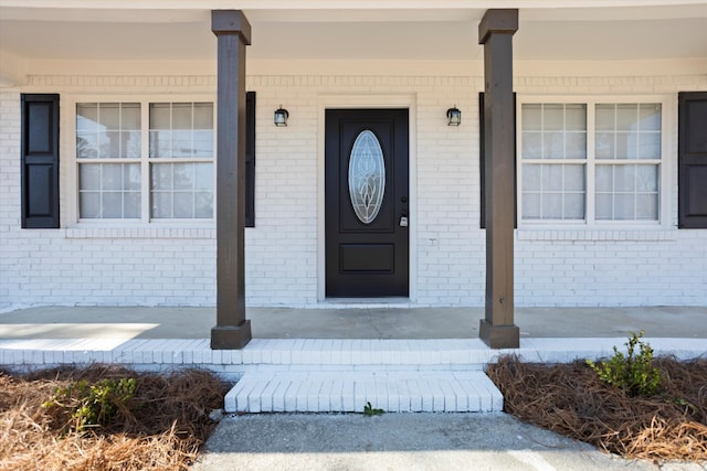 view of exterior entry featuring brick siding