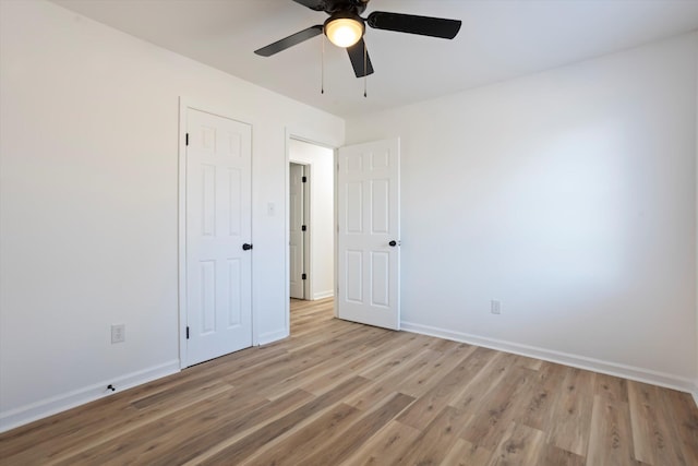 unfurnished bedroom with light wood-style floors, a closet, baseboards, and a ceiling fan