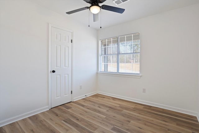 unfurnished room featuring visible vents, ceiling fan, baseboards, and wood finished floors