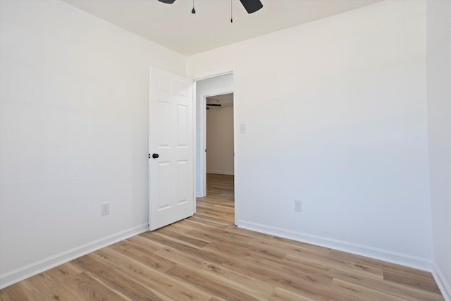 empty room featuring baseboards, ceiling fan, and light wood-style floors