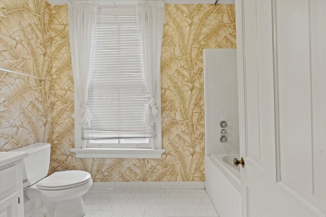 bathroom featuring a tub, tile patterned flooring, and toilet