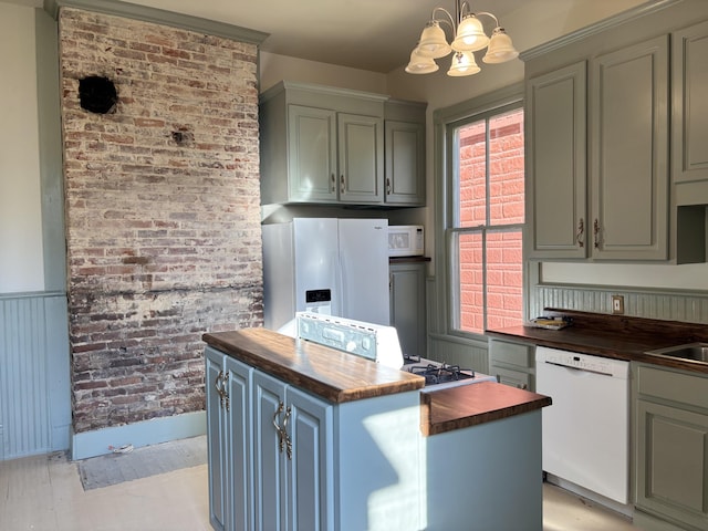 kitchen with wooden counters, brick wall, white appliances, a chandelier, and hanging light fixtures