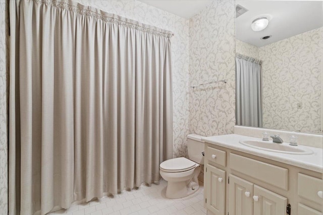 bathroom with tile patterned flooring, vanity, and toilet