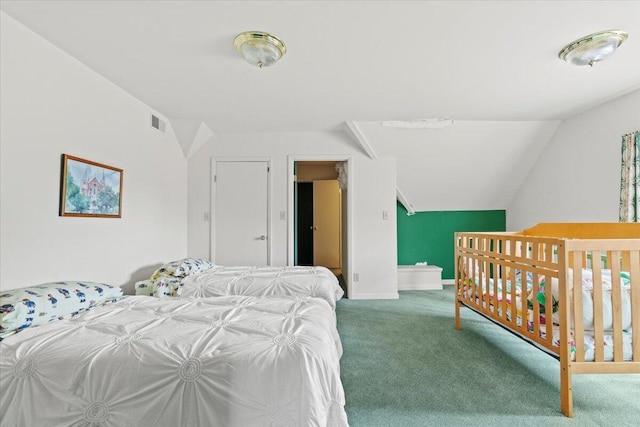 carpeted bedroom featuring ensuite bath and lofted ceiling