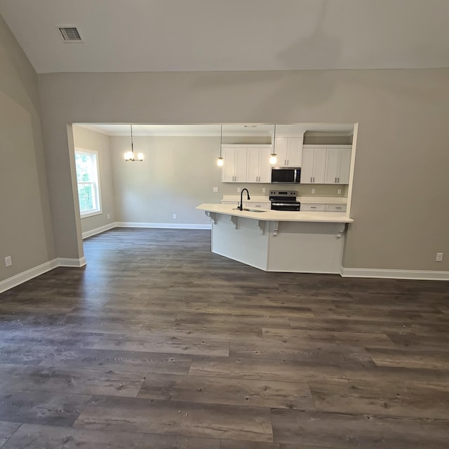 556 Hillman St, Warrenville, SC 29851 - kitchen featuring appliances with stainless steel finishes, dark wood-style flooring, a kitchen bar, light countertops, and white cabinetry