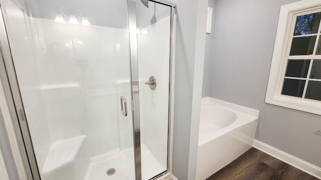 bathroom featuring wood-type flooring and shower with separate bathtub