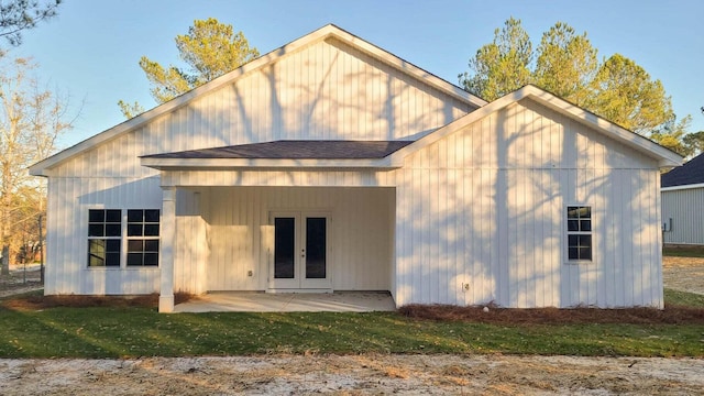 back of property with a yard, a patio area, and french doors