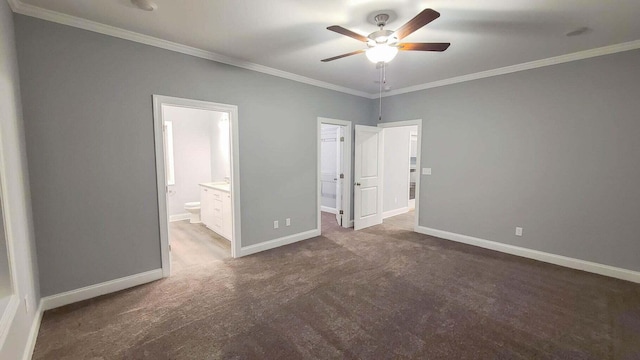 unfurnished bedroom featuring ensuite bath, ornamental molding, a spacious closet, and dark colored carpet