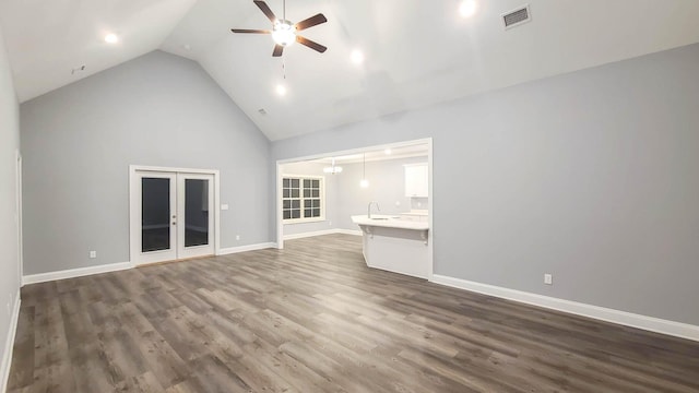 unfurnished living room with dark hardwood / wood-style floors, high vaulted ceiling, sink, ceiling fan, and french doors