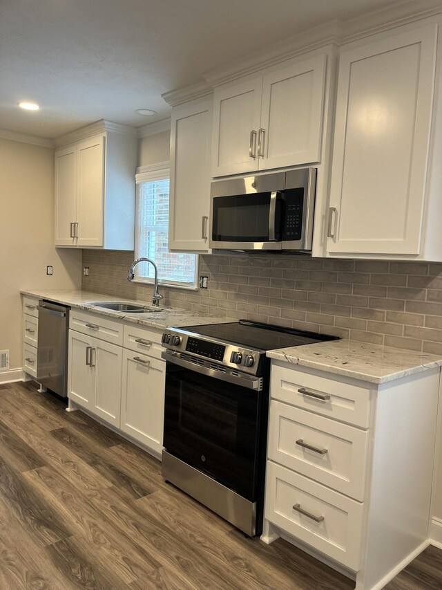 3517 Jamaica Dr, Augusta, GA 30909 - kitchen with appliances with stainless steel finishes, dark wood-style floors, white cabinetry, light stone countertops, and ornamental molding