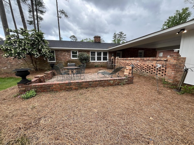 3517 Jamaica Dr, Augusta, GA 30909 - back of property with brick siding, a chimney, and a patio
