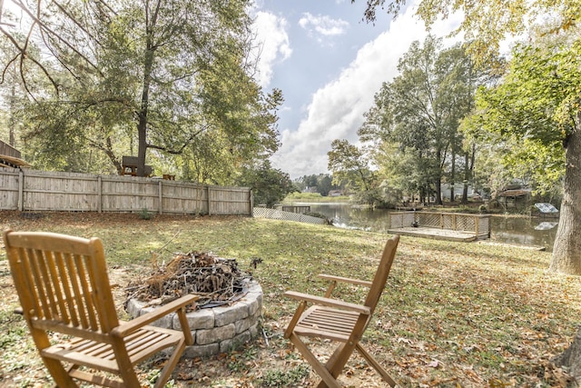 view of yard with a water view and a fire pit