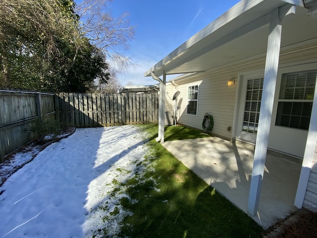 yard covered in snow featuring a patio