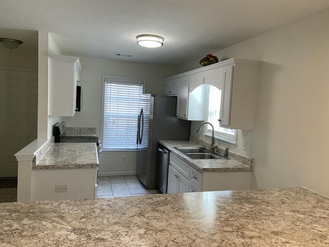 kitchen with sink, white cabinetry, light tile patterned floors, and stainless steel appliances