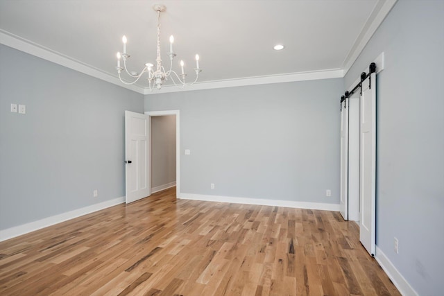 110 Collin Reeds Rd, North Augusta, SC 29860 - spare room with a barn door, a chandelier, ornamental molding, light wood-type flooring, and baseboards