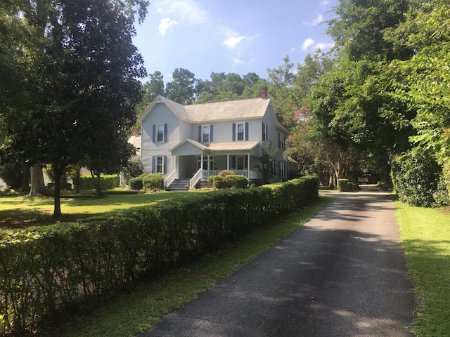 view of front of property featuring a front yard and covered porch