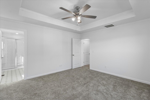 carpeted empty room featuring crown molding, a tray ceiling, and ceiling fan