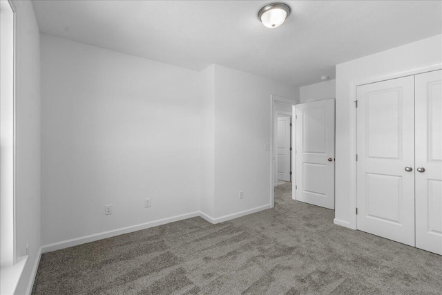 unfurnished bedroom featuring light carpet and a closet