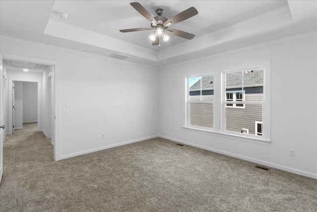 spare room featuring crown molding, light colored carpet, ceiling fan, and a tray ceiling