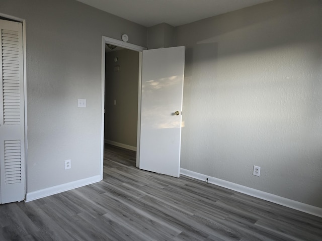 unfurnished bedroom featuring a closet and hardwood / wood-style floors