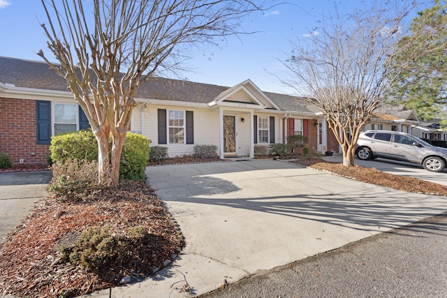 ranch-style home featuring concrete driveway and brick siding