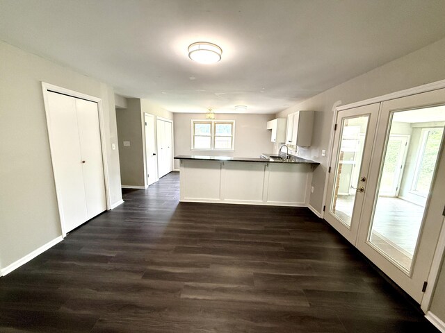 231 Norma Ln, Evans, GA 30809 - kitchen featuring a peninsula, dark wood-type flooring, a sink, and baseboards