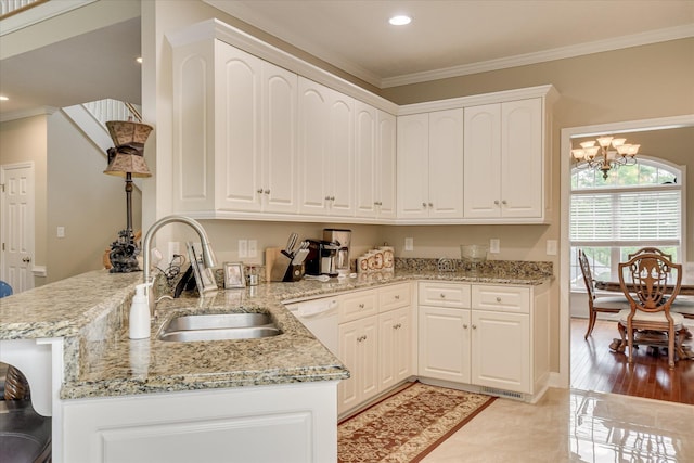 322 Farmington Dr, Evans, GA 30809 - kitchen with a sink, a peninsula, light stone counters, ornamental molding, and white cabinets