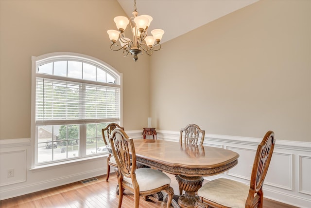 322 Farmington Dr, Evans, GA 30809 - dining room featuring a chandelier, wainscoting, lofted ceiling, light wood finished floors, and a decorative wall