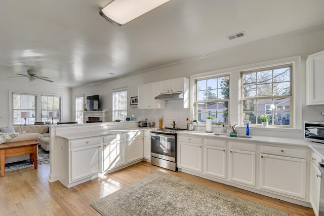 1321 Holden St, Augusta, GA 30904 - kitchen featuring stainless steel appliances, a peninsula, backsplash, open floor plan, and under cabinet range hood