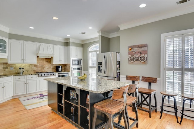 5407 Kiokee Ridge Rd, Evans, GA 30809 - kitchen with custom exhaust hood, white cabinets, and stainless steel appliances