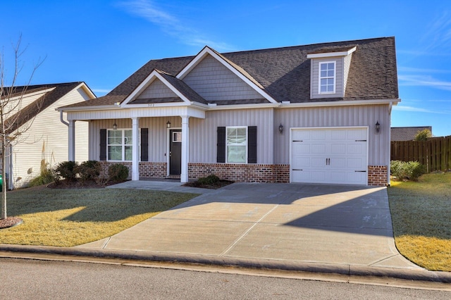 view of front facade featuring covered porch, a front yard, and a garage