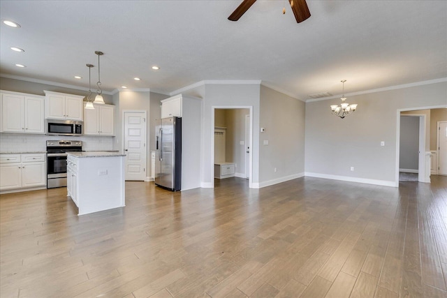 kitchen with stainless steel appliances, pendant lighting, white cabinets, and a center island