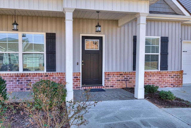 view of exterior entry featuring a garage and a porch