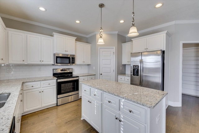 kitchen with a kitchen island, white cabinetry, stainless steel appliances, backsplash, and hanging light fixtures