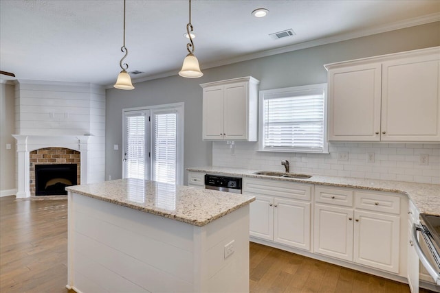 kitchen with sink, hanging light fixtures, white cabinets, and tasteful backsplash