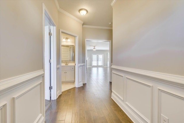 hallway featuring ornamental molding, hardwood / wood-style floors, and sink