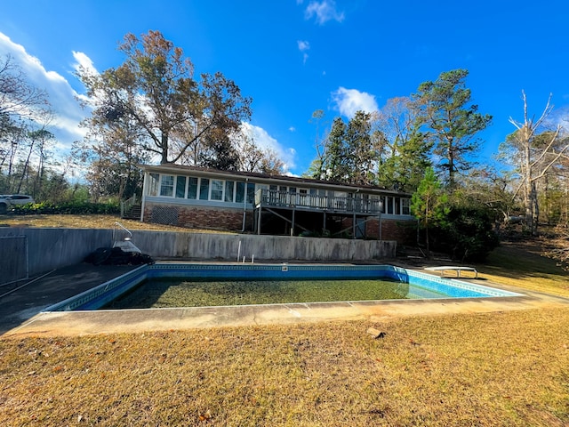 back of property featuring a swimming pool side deck and a yard