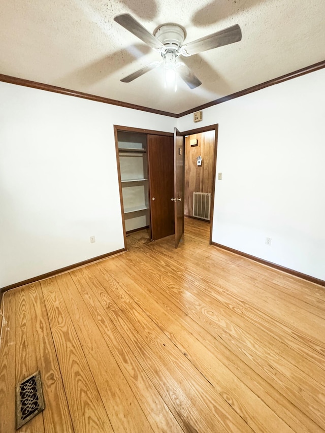 unfurnished bedroom with ceiling fan, a closet, a textured ceiling, and light hardwood / wood-style flooring