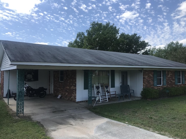 ranch-style home with a front lawn, a porch, and a carport